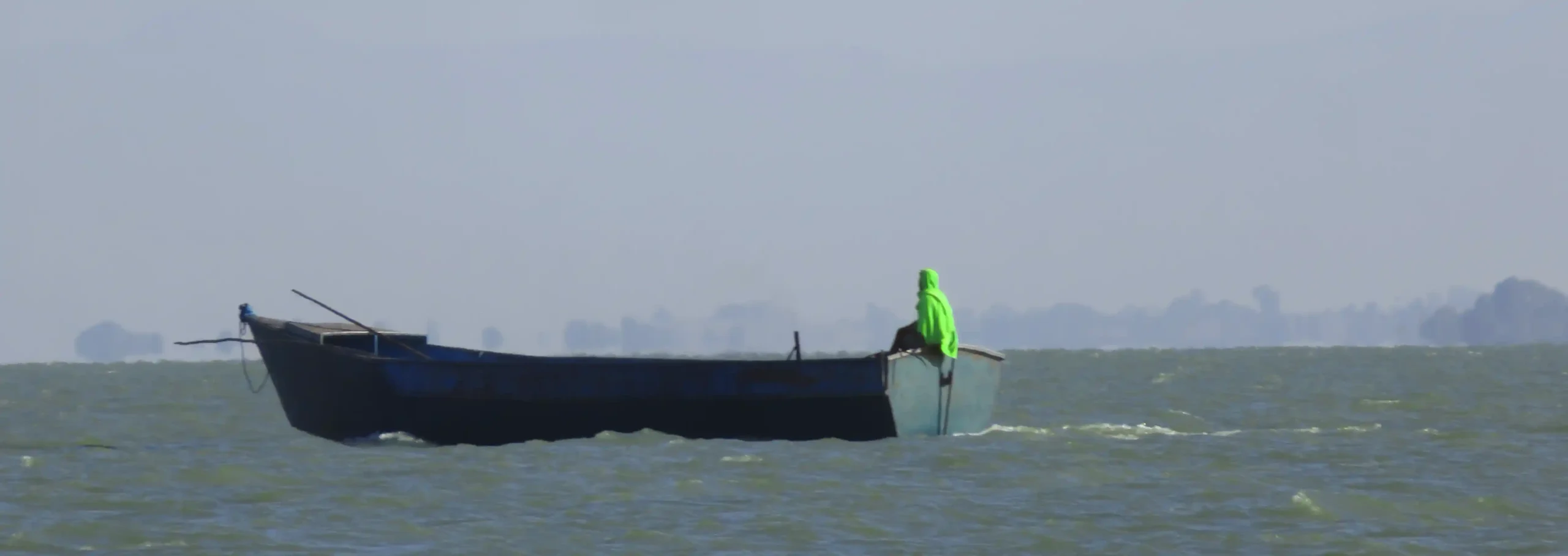 El barquero del lago Tana con su gran bote por las aguas.