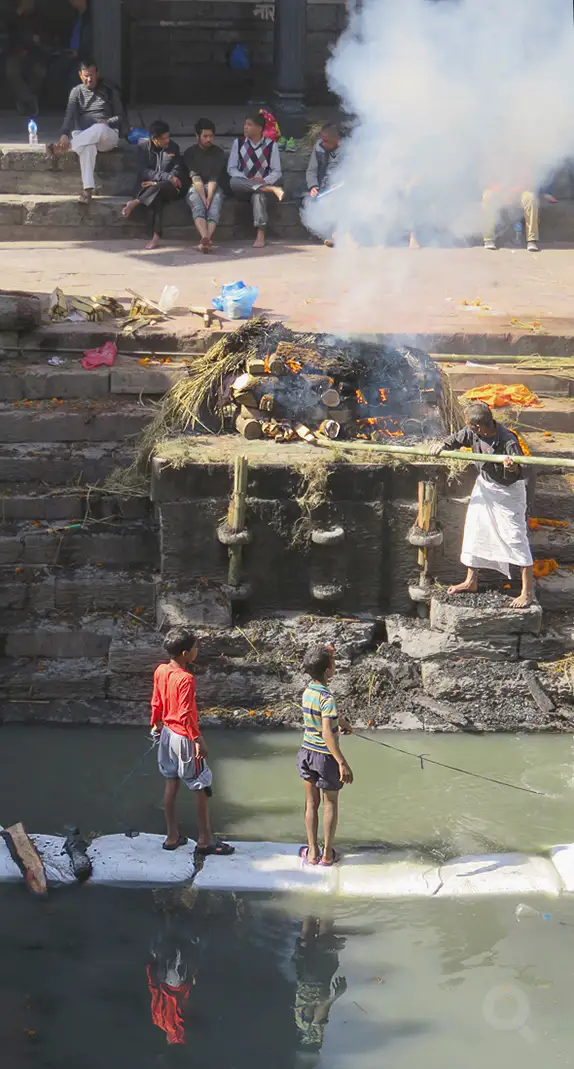 En las escalinatas de Pasupatiná, chavales recuperan con imanes las monedas tiradas al Bagmati durante las cremaciones.