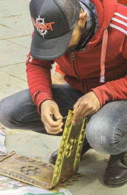 El latonero haciendo arreglos en el patrimonio arquitectónico de Katmandú. 