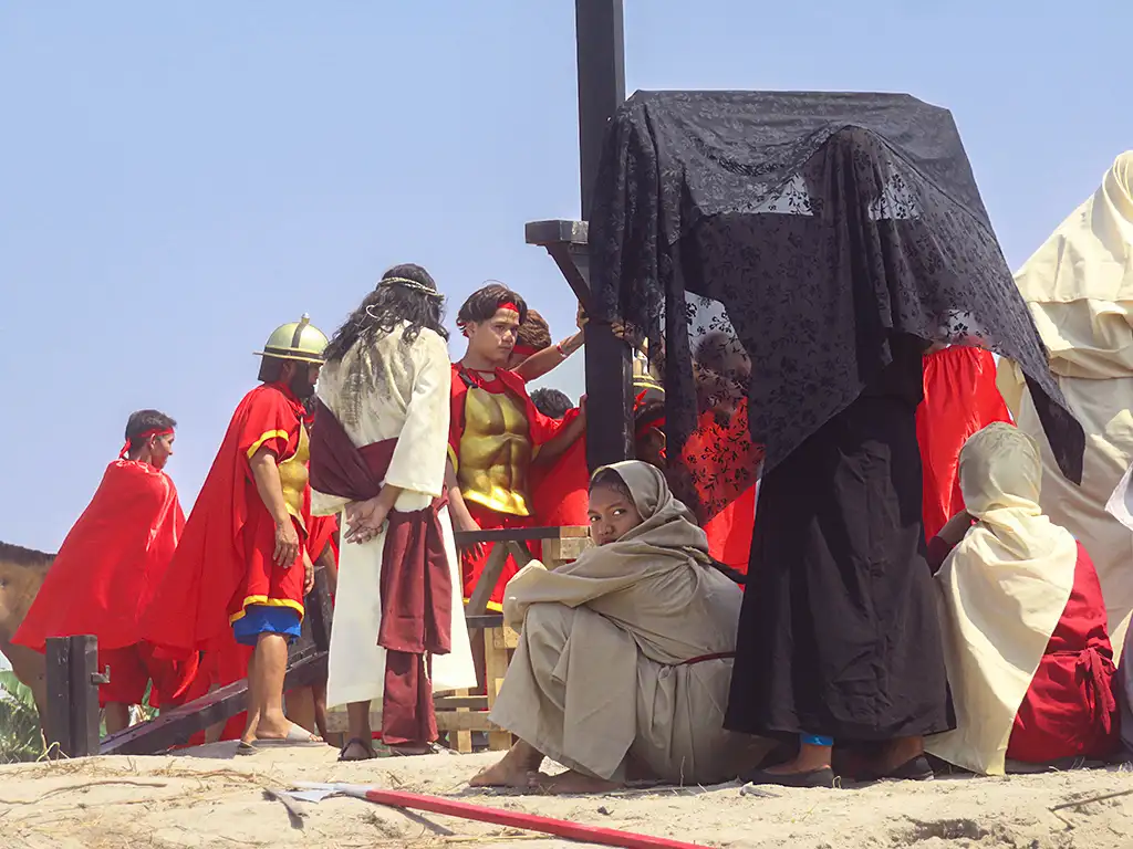 Interpretación teatral y antropológica de la cruz en el país católico de Asia con personajes vestidos para la ocasión.