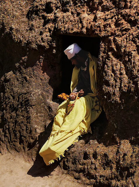 Ermitaño en una hoquedad del recinto de la Lalibela a pleno sol.